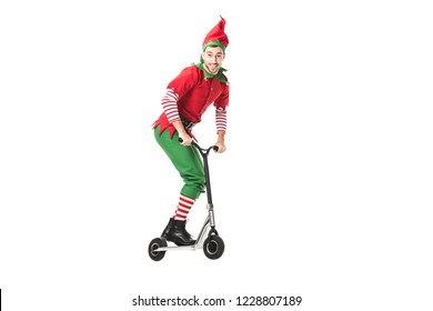 excited man in christmas elf costume jumping in air on push-cycle isolated on white