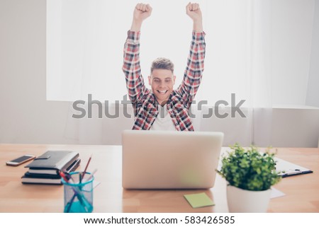 Excited man completed task and triumphing with raised hands
