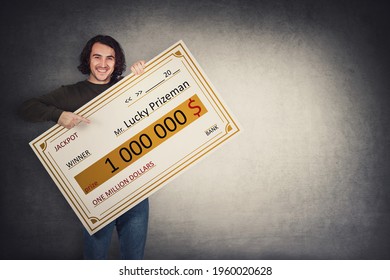 Excited man holding a lottery winner bank check. Happy guy jackpot winning one million dollars prize. Big banner announcing the main award. Wealth, luck and success concept. Becoming a millionaire