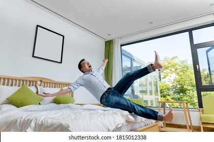 Excited man jumping to the bed.