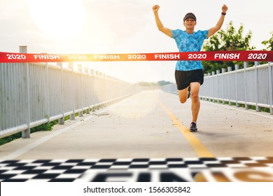 Excited Man Runner Crossing The 2020 Finish Line Of Marathon. 2020 Success Concept
