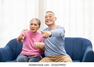 Excited Mature Couple, Senior Man And Woman Watching Tv, Senior Sport Fans Celebrating Favorite Team Victory, Sitting On Cozy Couch And Eating Popcorn Snack At Home, Enjoying Weekend. Happy Senior.