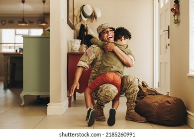 Excited military mom embracing her son after returning home from the army. Cheerful female soldier having a joyful reunion with her young child after military deployment.