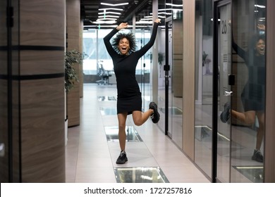 Excited Mixed-race Businesswoman Jumps Dance In Office Hallway Raise Hands Scream With Joy Celebrates Career Advancement, Salary Growth, Hired Recruited African Woman Feels Happy Got Dream Job Concept