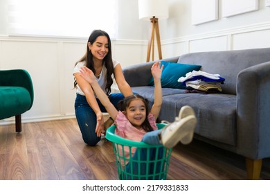 Excited Mom And Happy Little Girl Playing A Game While Doing Laundry Together And Having Fun As A Family At Home