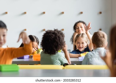 Excited Multiethnic Kids Waving Hands During Lunch In School Canteen