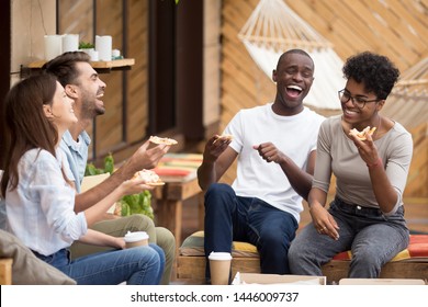 Excited Multiethnic Millennial Friends Sit In Restaurant Outside Eat Delicious Pizza Laugh Having Fun, Overjoyed Diverse Young People Feel Happy Smiling Relaxing Together Enjoying Italian Fast Food