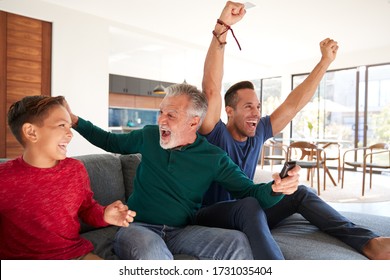 Excited Multi-Generation Male Hispanic Family Celebrating Watching Sports On TV