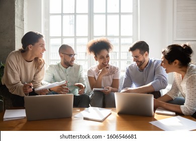 Excited multiracial diverse young people have fun make notes use laptops studying indoors together, overjoyed multiethnic international students or employees laugh brainstorming, teamwork concept - Shutterstock ID 1606546681