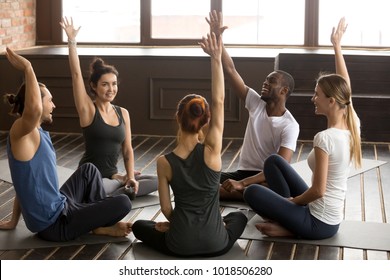 Excited Multiracial People Raising Hands At Yoga Training Celebrating Unity In Healthy Life, Diverse Happy Friends Doing Sports Together Supporting Group Getting Motivated Sitting On Mats In Studio