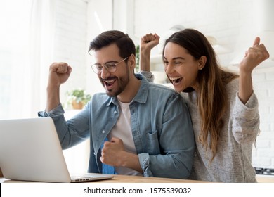 Excited overjoyed young family couple winners feel lucky got sale discount offer by email look at laptop screen celebrate online victory internet auction bid lottery win in app computer technology