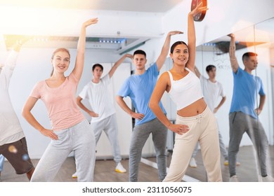 Excited positive diverse men and women of different ages stretching before modern dancing class in school for adults - Powered by Shutterstock