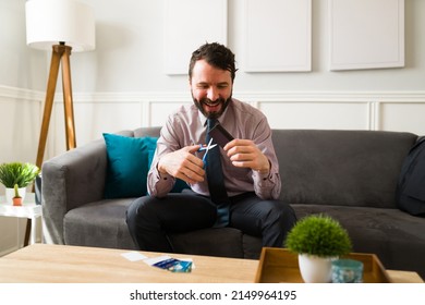 Excited Rich Man With No Debts Smiling While Cutting His Credit Card. Happy Man With Financial Security