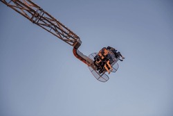 Excited Riders On Sky-High Amusement Park Swing
