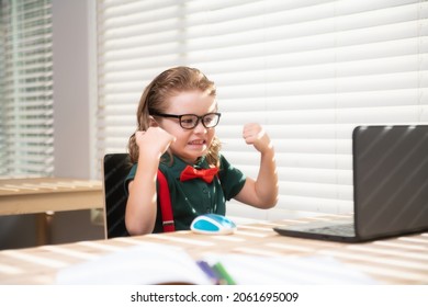 Excited schoolboy using a laptop and study online lesson. Pupil at school. Cute child using laptop computer, studying online. - Shutterstock ID 2061695009