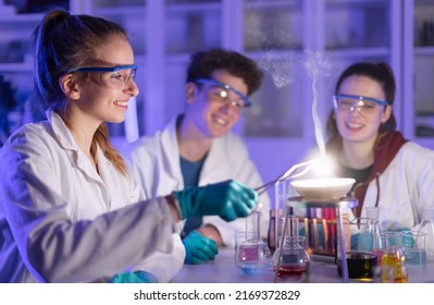 Excited science students doing chemical experiment in the laboratory at university. - Shutterstock ID 2169372829