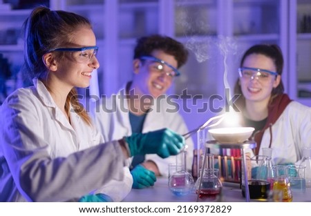 Excited science students doing chemical experiment in the laboratory at university.