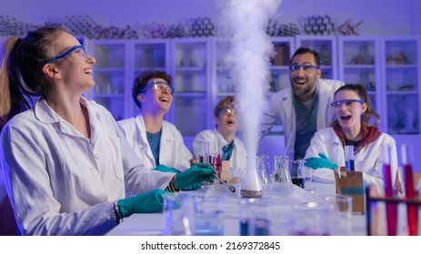 Excited science students with teacher doing chemical experiment in the laboratory at university.