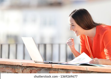 Excited Self Employed Checking Laptop Content Outdoors In A Balcony