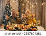 Excited senior couple is celebrating new year and christmas eve with grandchild with confetti in the midnight.