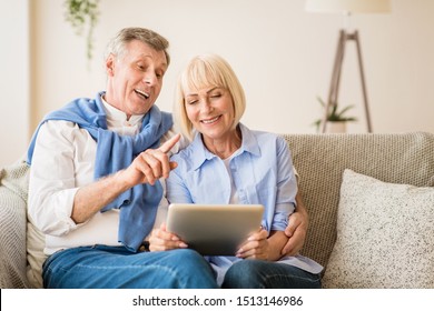 Excited senior couple making video call on tablet, chatting with grandchildren online, free space