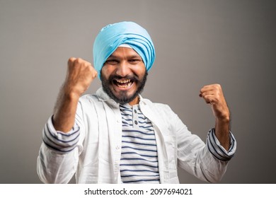 Excited sikh man celebrating succes by shouting and showing hand gesture by looking at camera - concept of job promotion,good news and won lottery.