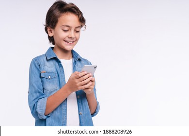 Excited Small Kid With A Mobile Phone Isolated Over White Background