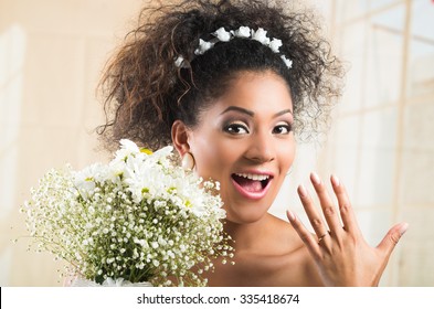 Excited smiling African American  bride showing her wedding ring