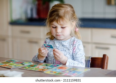 Excited Smiling Cute Toddler Girl Playing Picture Card Game. Happy Healthy Child Training Memory, Thinking. Creative Indoors Leisure And Education Of Kid. Family Activity At Home.