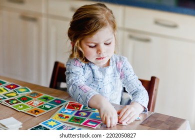 Excited Smiling Cute Toddler Girl Playing Picture Card Game. Happy Healthy Child Training Memory, Thinking. Creative Indoors Leisure And Education Of Kid. Family Activity At Home.