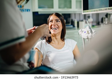 Excited Smiling Woman In The Dental Office On A Routine Check-up.Orthodontic Consultation.Dental Hygiene.Dentist Appointment.Healthcare Insurance.Teeth Whitening Treatment. Oral Surgery Patient.