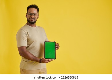 Excited software developer showing digital tablet with green screen - Shutterstock ID 2226580965