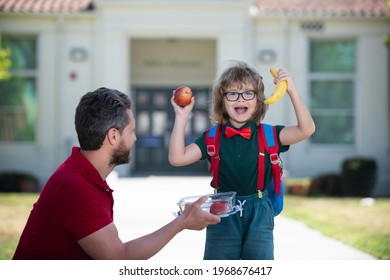 Excited son schoolboy eating tasty lunch outdoors. Happy father and son go to elementary school. Parent taking child to primary school.