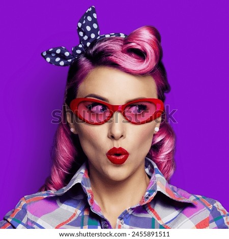 Excited surprised woman. Pinup girl  in red glasses looking sideways. Purple head model at retro fashion vintage concept. Isolated against bright color background. Square composition.