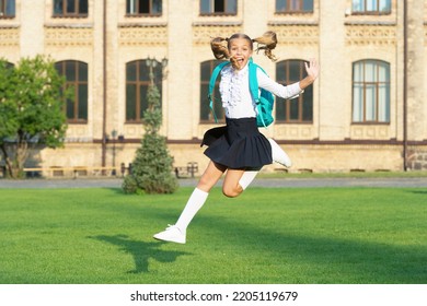 Excited teenage girl in school uniform jumping midair. Energetic schoolgirl back to school