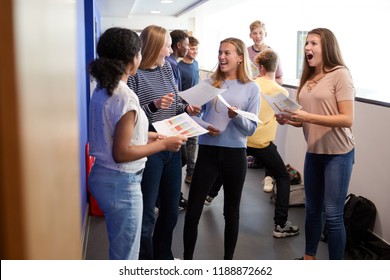 Excited Teenage High School Students Celebrating Exam Results In School Corridor