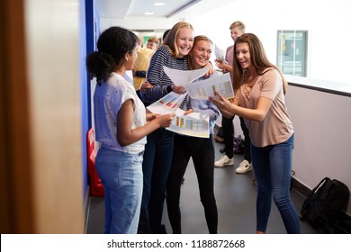 Excited Teenage High School Students Celebrating Exam Results In School Corridor