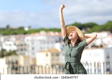 Excited tourist raising arm on summer vacation in a rural town a sunny day - Shutterstock ID 1840649797