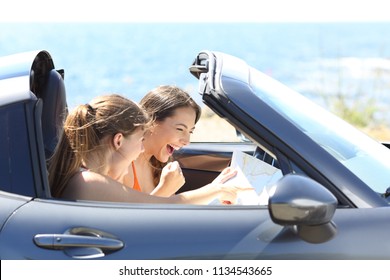 Excited tourists reading a paper map in a car on summer vacation - Powered by Shutterstock