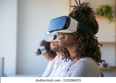 Excited users testing VR game. Diverse group of people wearing VR headset, turning face up. Virtual reality game concept - Powered by Shutterstock