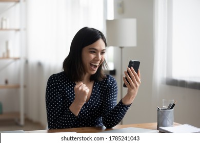 Excited Vietnamese young woman look at cellphone screen triumph win online lottery or app game. Overjoyed Asian millennial girl feel euphoric read good news email on smartphone. Success concept