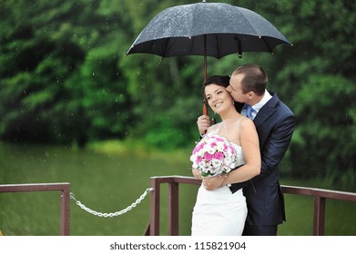 An Excited Wedding Couple In A Rainy Day