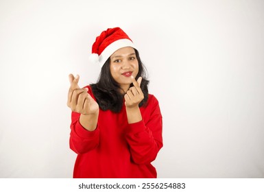 Excited woman blowing a kiss in a Santa hat, spreading holiday love and cheer - Powered by Shutterstock