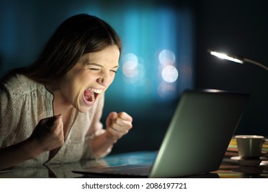 Excited Woman Checking Laptop News At Home In The Night