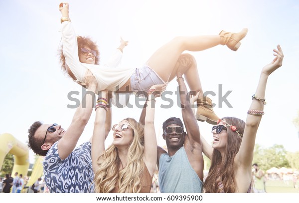 Excited woman\
crowd surfing at music festival\
