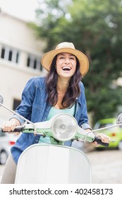 Excited Woman Enjoying Moped Ride In City