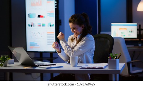 Excited woman feel ecstatic reading great online news on laptop working overtime in start up company office. Happy employee using modern technology network wireless studying writing, searching - Shutterstock ID 1893769429