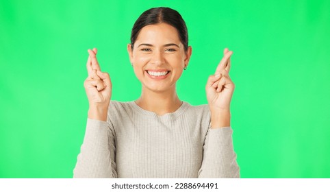 Excited woman, fingers crossed and face on green screen, background and studio for good luck. Portrait of happy female model hope for winning prize, wish and optimism with emoji sign, hands and smile - Powered by Shutterstock