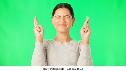 Excited woman, fingers crossed and face on green screen, background and studio for good luck. Portrait of happy female model hope for winning prize, wish and optimism with emoji sign, hands and smile - Powered by Shutterstock