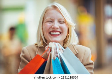 Excited Woman Having Fun Shopping And Holding Bags While Looking At The Camera Smiling. Beautiful Woman Holding Shopping Bags And Smiling. Young Beautiful Girl Is Shopping In The Mall 